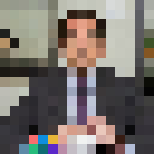 Middle-aged Caucasian male with receding dark hair, dressed in a business suit. Expressive eyebrows and a slightly bemused expression